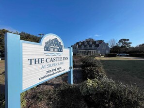 Skilt for The Castle Inn ved Silver Lake, med et stort hus i baggrunden.