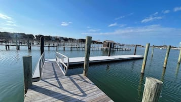A wooden dock extending into calm water with a clear sky above.