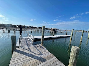 A wooden dock extending into calm water with a clear sky above.