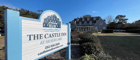Segnaletica per The Castle Inn a Silver Lake, con una grande casa sullo sfondo.