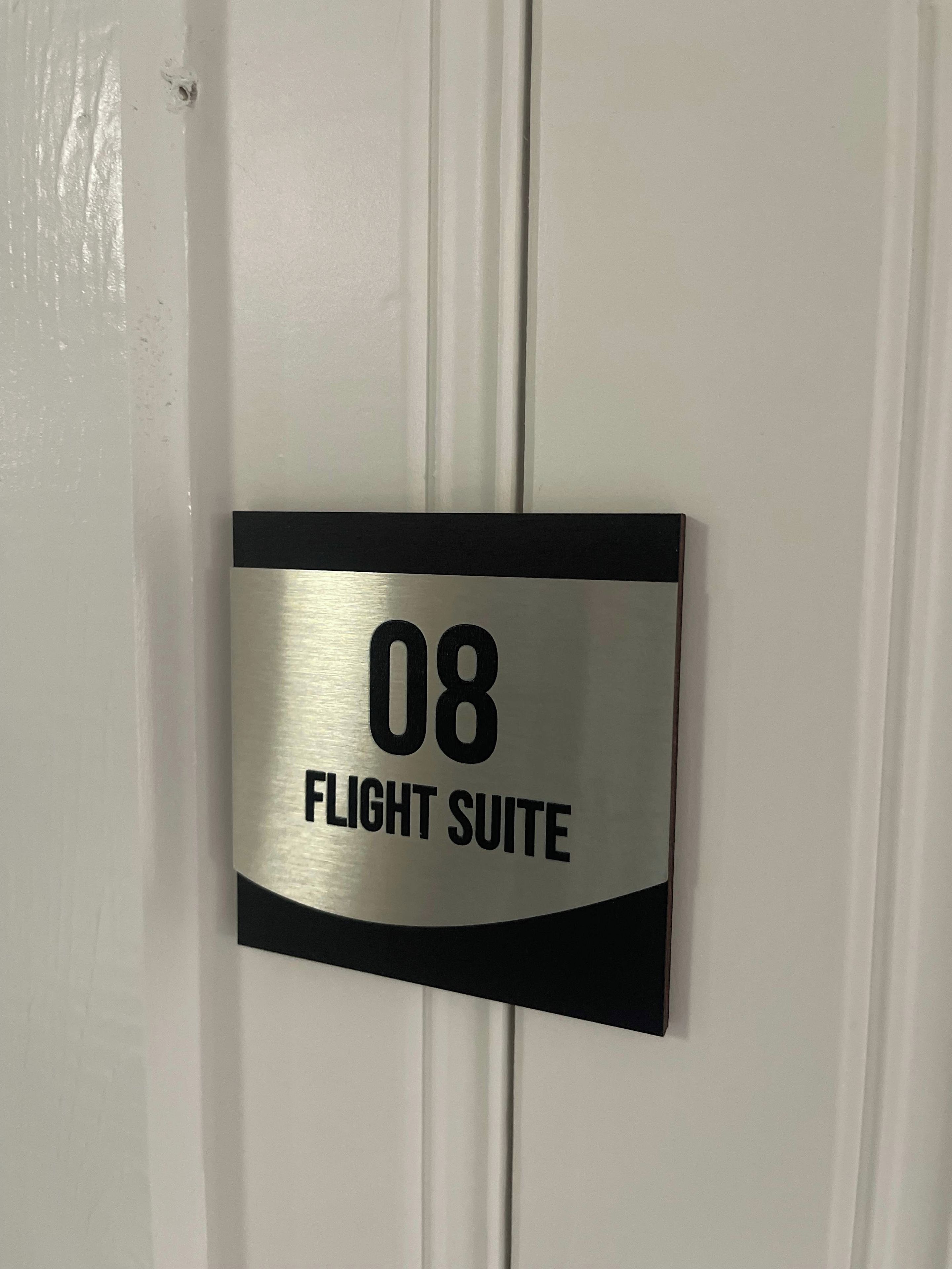 A door with a sign indicating '08 FLIGHT SUITE.'