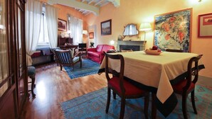 Un comedor con una mesa dispuesta para cuatro personas, un sofá rojo y una chimenea.