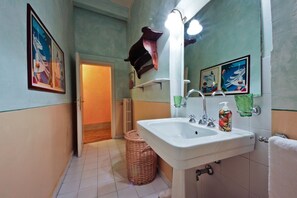 Ein Badezimmer mit Waschbecken, Spiegel und Handtuchhalter an der Wand.
