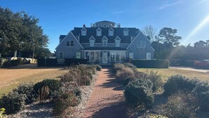 A large, two-story house with a symmetrical facade, multiple windows, and a central entrance. - 04-The Seashell Suite at The Castle Inn (Ocracoke)