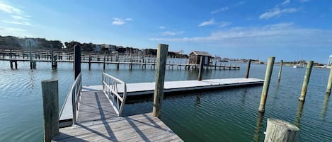 A wooden dock extending into calm water with a clear sky above.