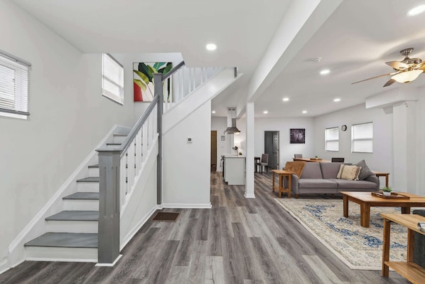 A spacious living area with a staircase, a gray sofa, and a coffee table.