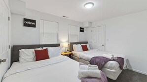 A hotel room with two beds, a nightstand with a lamp, and two signs on the wall reading "believe" and "dream". - Mins to Children's Museum - Capitol Avenue Classic (Indianapolis)