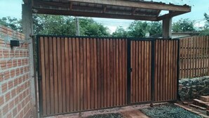 A gated entrance with a wooden fence and a metal gate. - Department 2 (Puerto Iguazú)