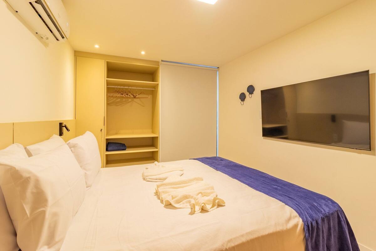 Ein Hotelzimmer mit Bett, Kleiderschrank, Fernseher und Schrank.