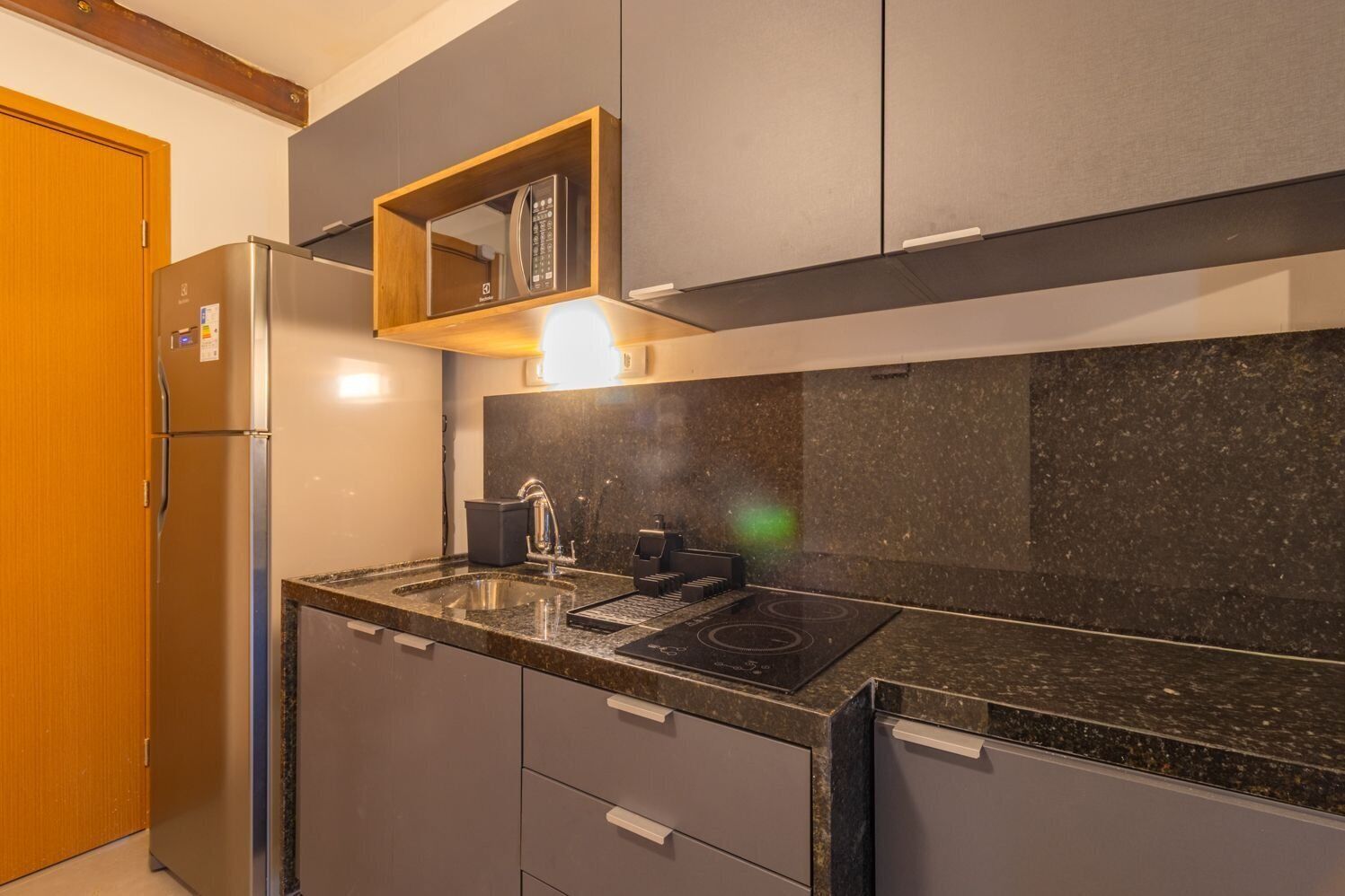 A compact kitchen with a built-in refrigerator, a stove, and a sink.