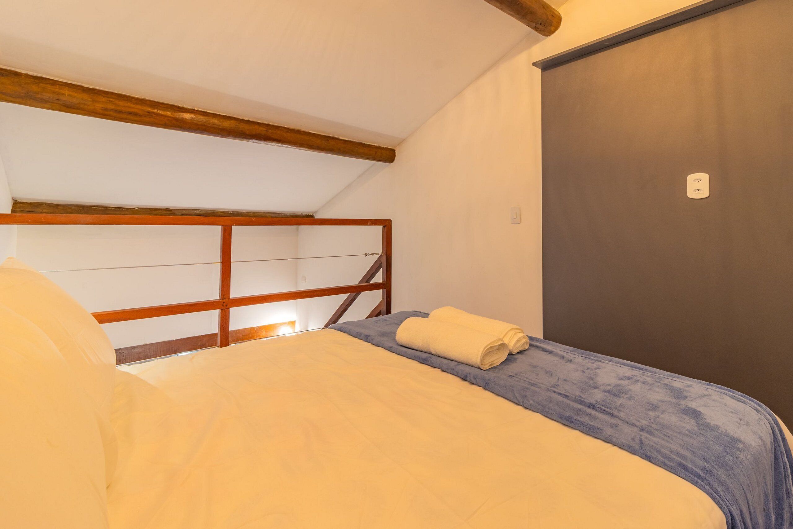 Una camera da letto con un letto a castello in legno, un letto singolo con coperta gialla e una porta grigia.