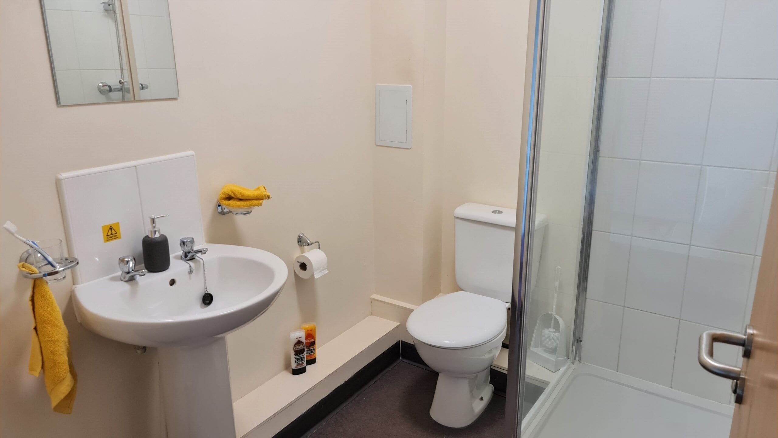 A bathroom with a sink, toilet, and glass shower enclosure.
