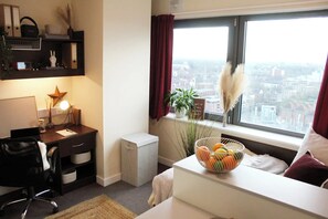 Ein moderner Büroraum mit Schreibtisch, Stuhl und einem Fenster mit Blick auf die Stadt.