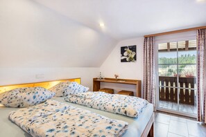 Une chambre à coucher avec un lit, un bureau et une vue sur l’extérieur.