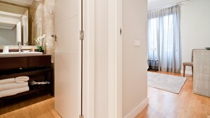 Een moderne badkamer met een grote spiegel, een wastafel en een handdoekrek.