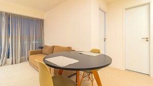 A modern living room with a round black table, a beige sofa, and a yellow chair. - Parque do Cais #1210 - Apt With a View by Carpediem (Recife)