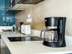 A modern kitchen with a black coffee maker, a white toaster, and a sink. - Casa Arno - Lovely Modern Apartment In Puerto De Mogan (Lomo Quiebre)