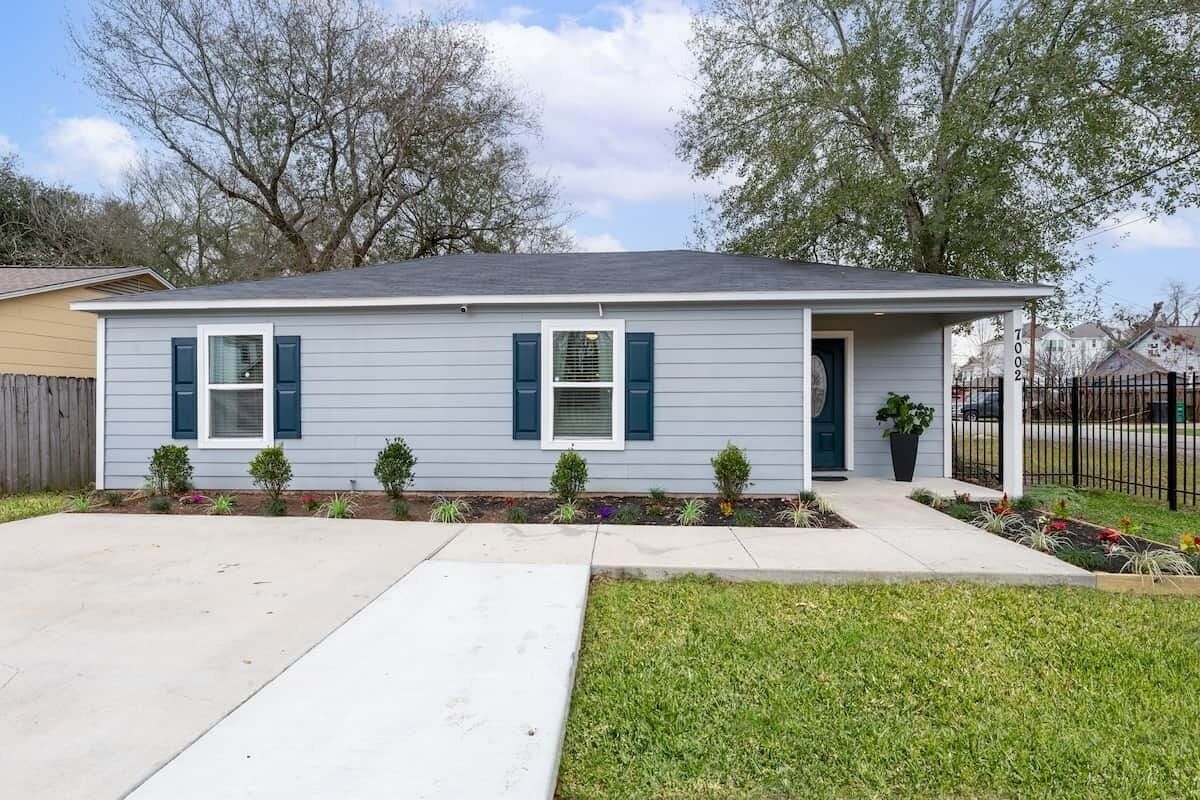 A single-story house with a front porch, a small garden, and a mailbox.