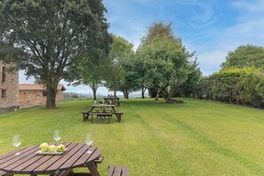 A grassy outdoor area with picnic tables and a stone building. - InfinityCoast 3 byFidalsa (Piélagos)