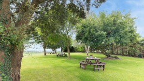 A grassy outdoor area with picnic tables and trees. - InfinityCoast 3 byFidalsa (Piélagos)