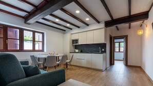 Un interior moderno con zona de comedor, cocina y sofá.