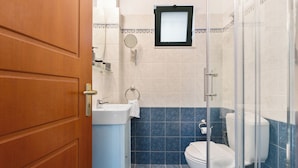 Ein Badezimmer mit Toilette, Waschbecken und Duschbereich.