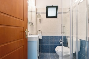 Ein Badezimmer mit Toilette, Waschbecken und Duschbereich.