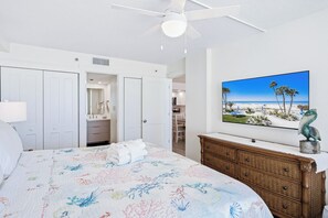A bedroom with a bed, a dresser, a TV, and a ceiling fan. - New Reno Gulf-Front 3 Bedroom Condo | Heated Pool & Hot Tub | Sand Castle I (Indian Shores)