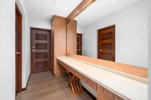 Ein schmaler Gang mit Holztüren, einer hölzernen Bank und einer weißen Arbeitsplatte.