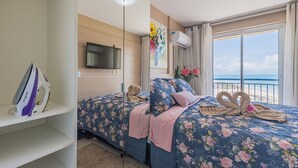 A hotel room with a bed, a TV, an air conditioner, and a view of the sea. - Beachvillage 1507n - Praia do Futuro por Carpediem (Fortaleza)