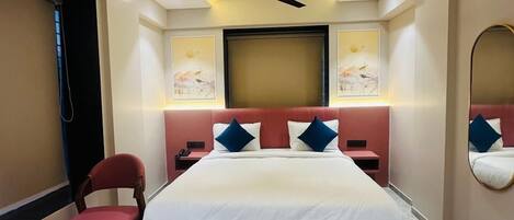 Un dormitorio moderno con una cama grande, un ventilador de techo y un aire acondicionado instalado en la pared.