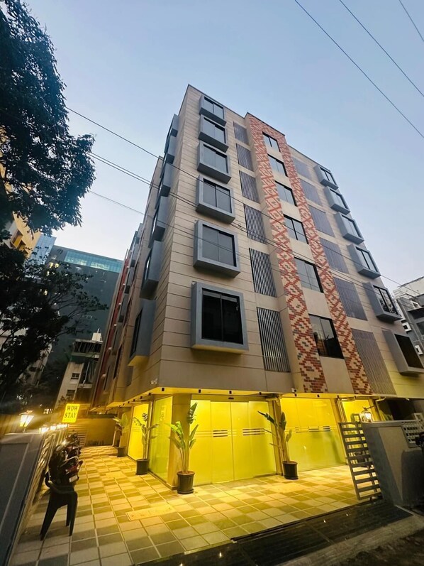 A multi-story building with a checkered floor pattern, a patterned facade, and a sign that reads 'WOW STAY'. - Hotel Wow stay - Balewadi Pune (Pune)