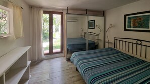 A bedroom with two beds, a window with curtains, a bedside table, and a framed picture on the wall. - Bikers cottage in the woods 5 minutes from the sea, (Finale Ligure)