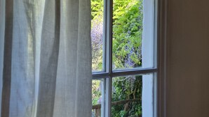 A window with a white frame and a view of greenery outside. - Bikers cottage in the woods 5 minutes from the sea, (Finale Ligure)