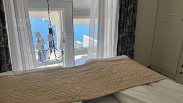 Une chambre à coucher avec un lit, un lustre et une vue sur la mer.