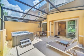 An outdoor patio with a hot tub, lounge chairs, and a covered seating area. - Perfect Disney Stay | 3BR Townhome w/ Private Spa (Kissimmee)