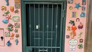A pink building with a green metal gate, decorated with various colorful tiles and sea creature ornaments. - Casa Irene by the beach with garden and A/C (Monterosso al Mare)