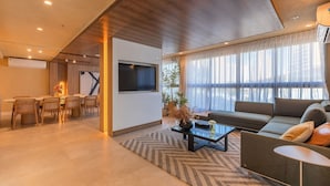 Ein modernes Wohnzimmer mit Sofa, Couchtisch und Essbereich.