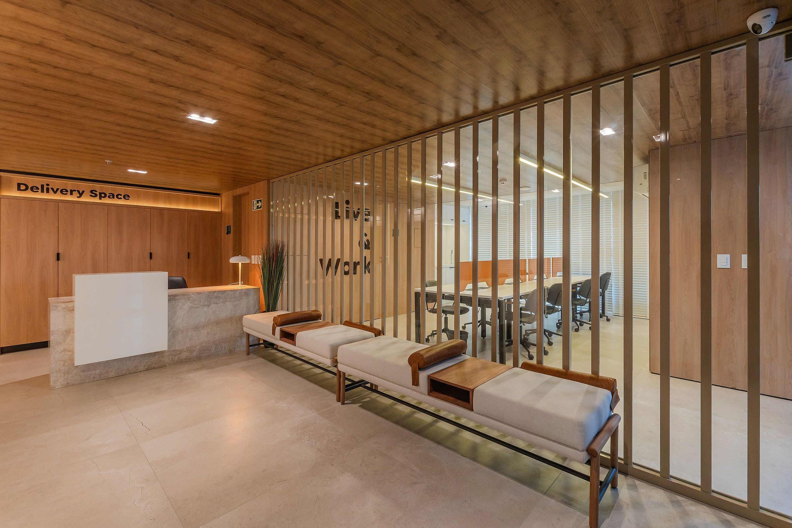 Uma área de recepção com balcão, espaço para sentar e uma placa com a inscrição 'Delivery Space'.