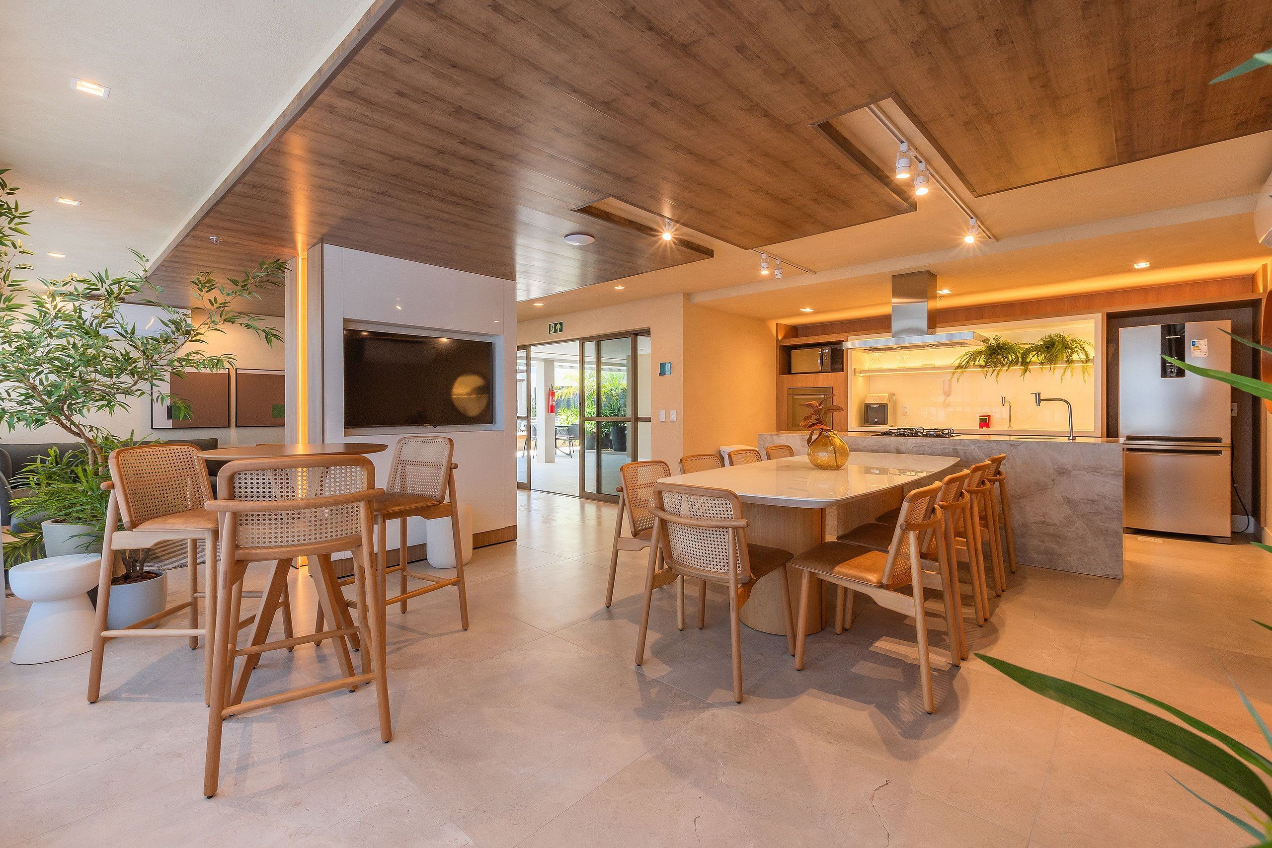 A modern kitchen with a central island, wooden chairs, and a dining table.