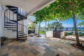A modern interior with a spiral staircase, outdoor seating area, and a view of the sea. - BEACH FRONT VILLA 11 Bedrooms Casa Playa Del Rey House (Jaco)