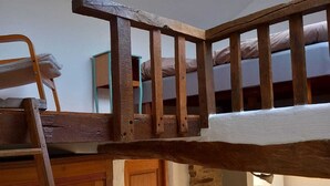 Ein Schlafzimmer im Loft-Stil mit einer Holzlade und Stockbetten.