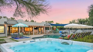 A backyard with a swimming pool, hot tub, and outdoor seating area with umbrellas. - Fun-Filled Oasis • Pool, Pickleball, Games Galore (Scottsdale)
