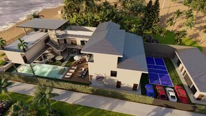 Een modern resort met een zwembad, tennisbaan en meerdere auto's op de oprit.
