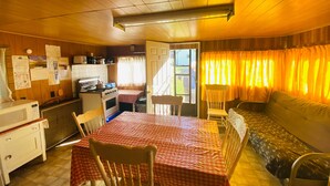 A compact kitchen with a stove, microwave, and dining table with chairs.