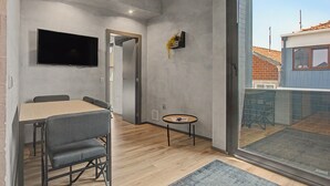 Ein modernes Interieur mit Essbereich, Fernseher und kleinem Tisch mit Pflanze.