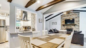 Una cocina moderna con gabinetes blancos, estufa integrada y un amplio ventanal.
