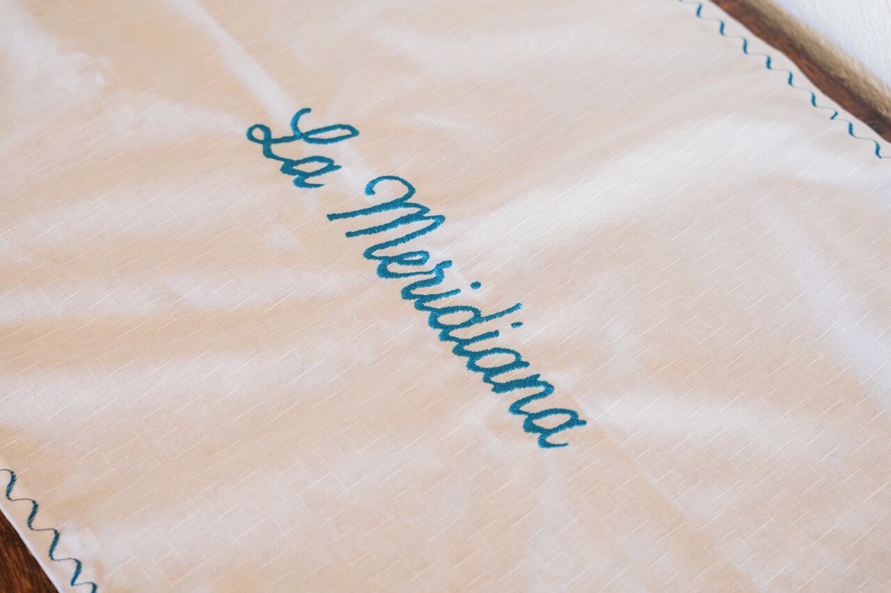 Detailaufnahme eines Stoffes mit der Stickerei 'La Meridiana' in Blau.
