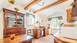 Een keuken met houten kastjes, een eettafel en een witte koelkast.