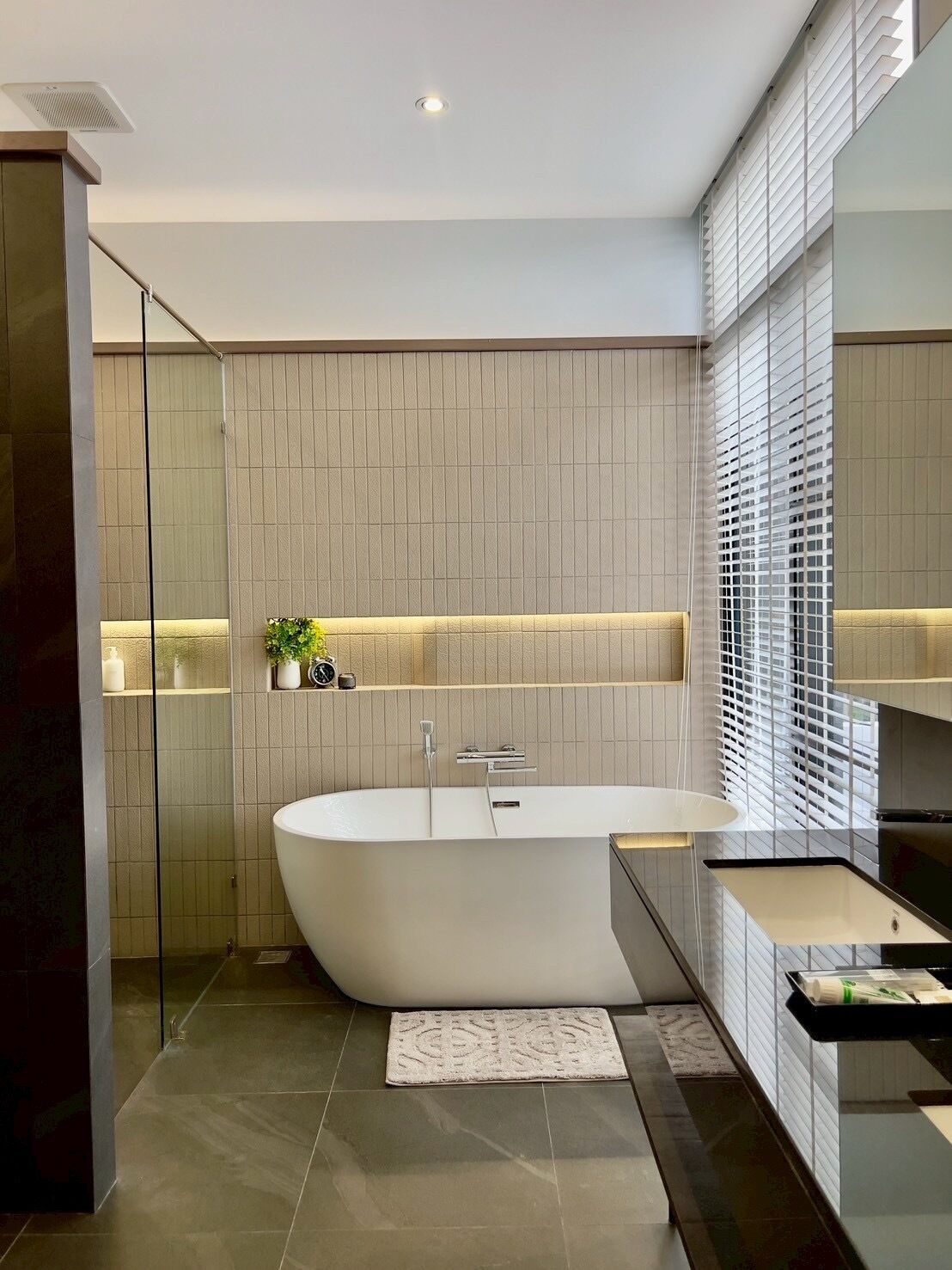A modern bathroom with a freestanding bathtub, a glass shower enclosure, and a vanity with a sink.